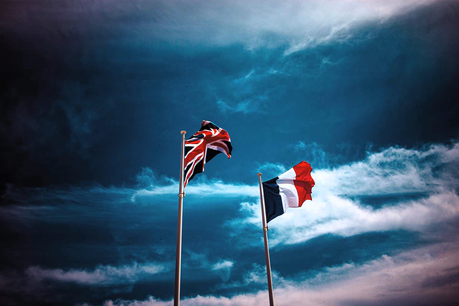 geo-trends.eu_Flags of the United Kingdom and France waving, symbolizing the nations’ shared struggles with political instability and military challenges in a tense geopolitical landscape