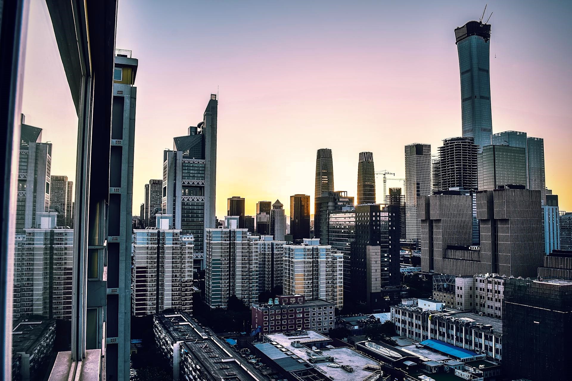 A view of Beijing’s skyline at sunset, featuring modern skyscrapers and residential buildings, symbolizing China’s blend of market-driven growth and strong state intervention