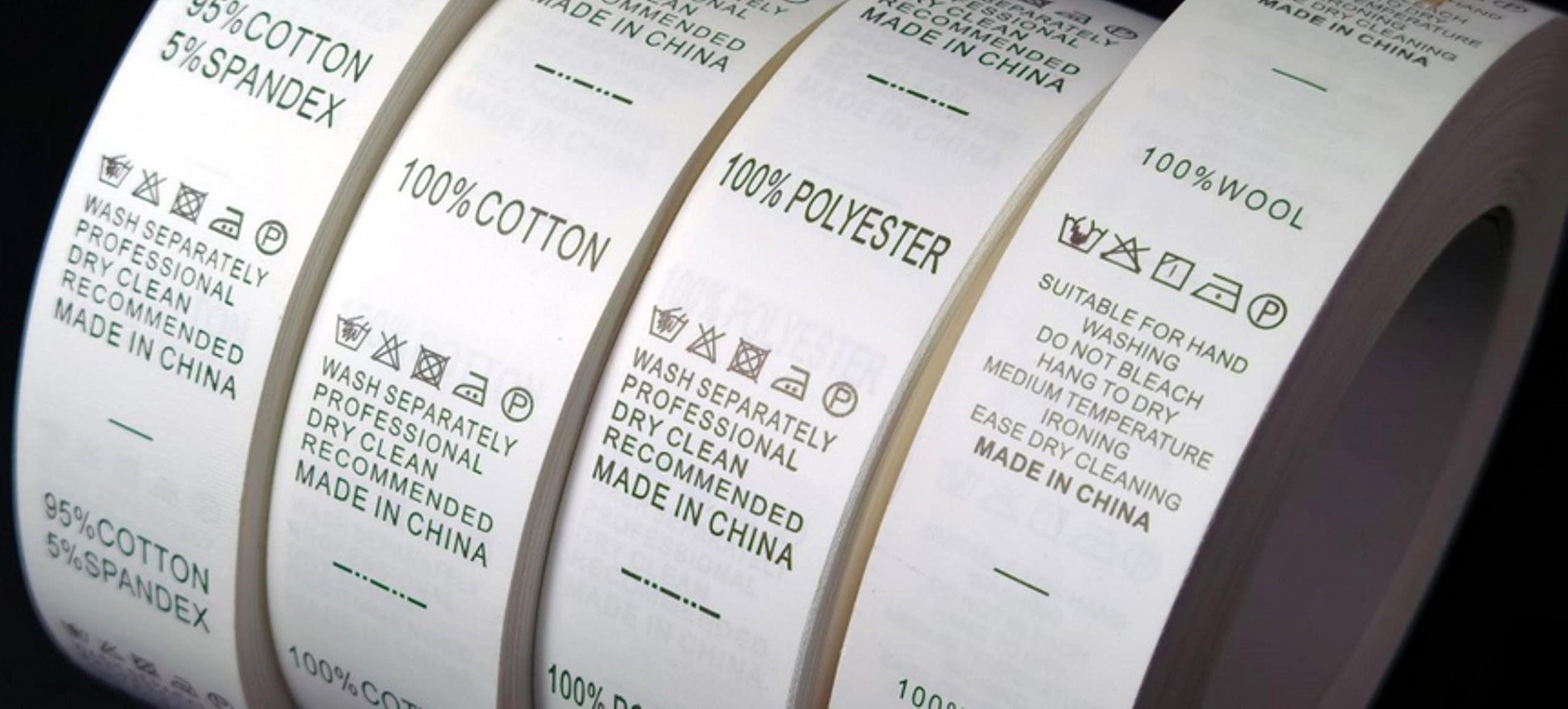 Multiple textile label rolls with fabric composition and care instructions, all prominently marked “Made in China,” highlighting China’s continued role in global manufacturing despite new U.S. tariffs