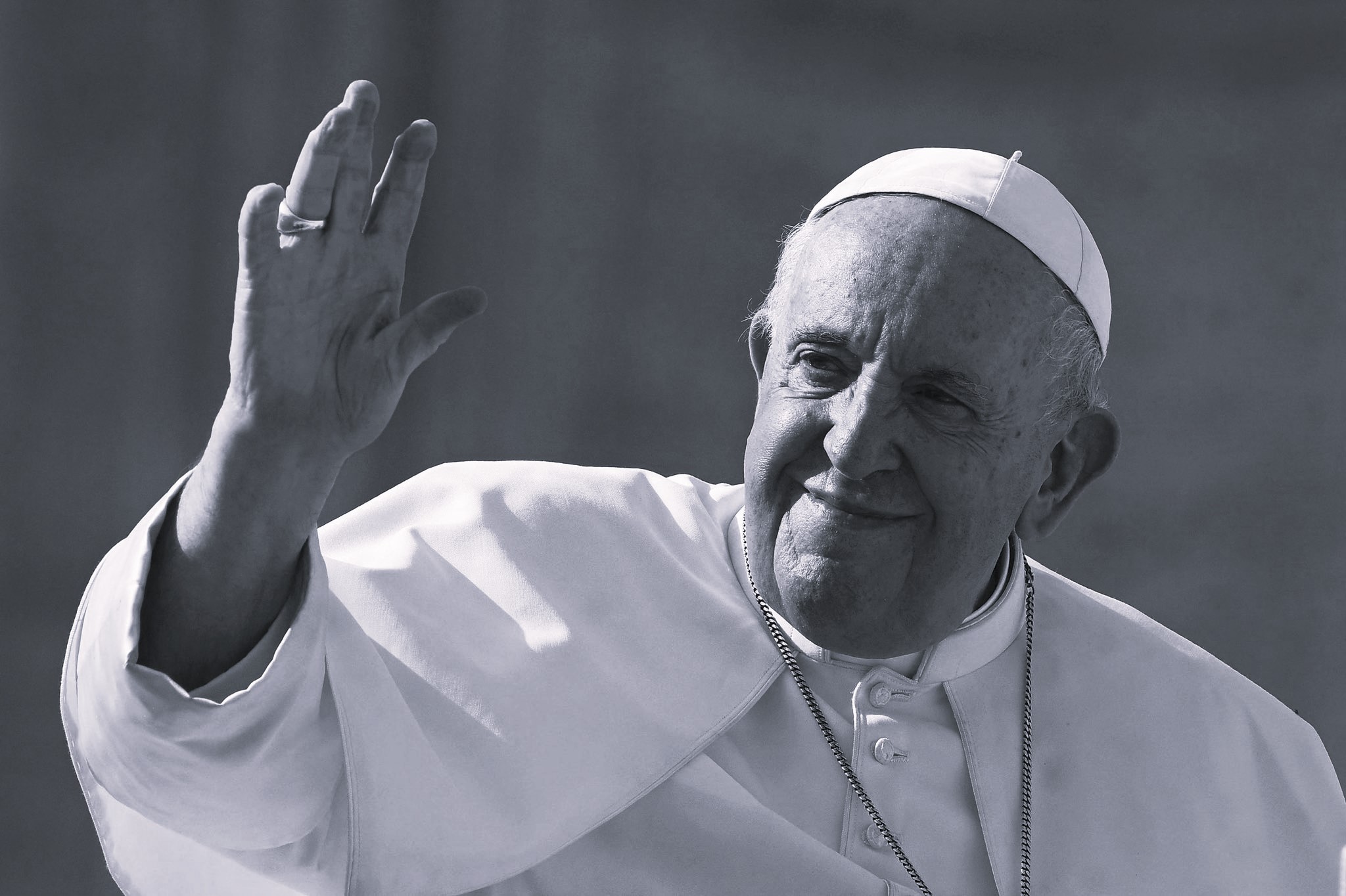 Black-and-white portrait of Pope Francis waving with a gentle smile, symbolizing his pastoral approach and enduring legacy