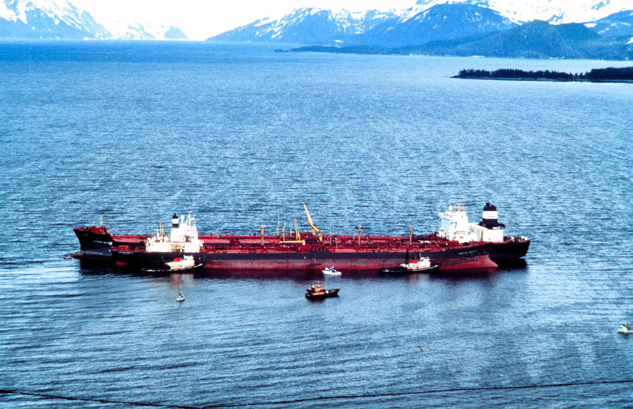 Aerial view of the damaged Exxon Valdez oil tanker surrounded by response vessels in Prince William Sound, Alaska