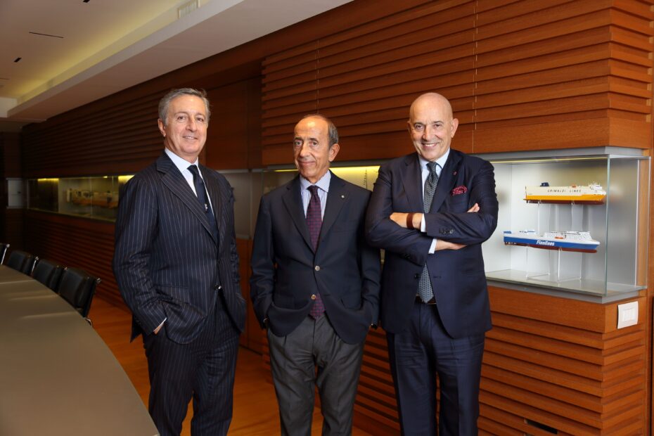 Grimaldi Group executives Diego Pacella, Gianluca Grimaldi, and Emanuele Grimaldi in corporate headquarters with ferry models
