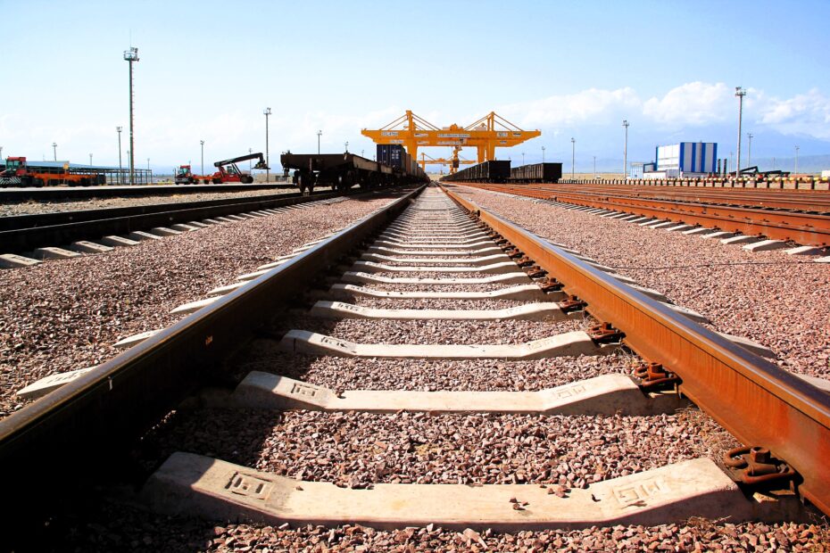 Railway tracks at KTZE Khorgos Gateway dry port leading toward container cranes, Central Asia corridor, Kazakhstan