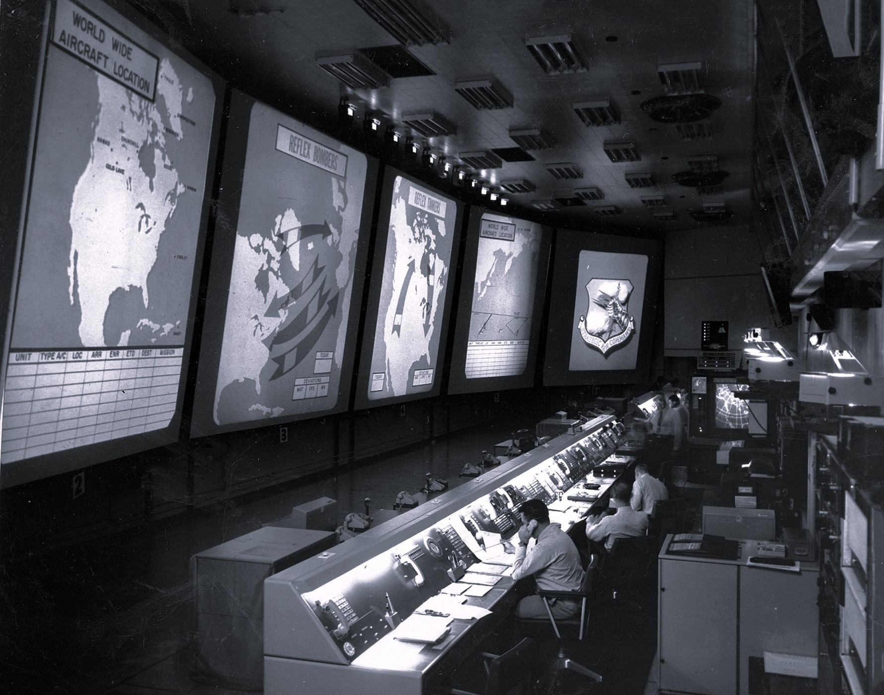 Black-and-white photo of analysts studying aerial reconnaissance images at the National Photographic Interpretation Center during the Cuban Missile Crisis