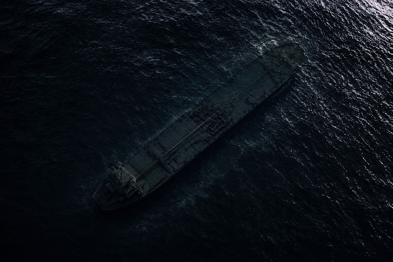 Dark aerial view of a shadowy VLCC tanker barely visible beneath black ocean water, creating a minimalist and atmospheric maritime scene