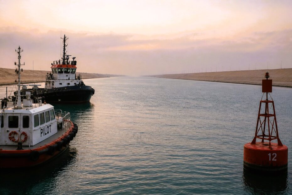 Pilot boat, tug, and buoy in a quiet Suez Canal scene with no passing ships and empty waterway stretching ahead