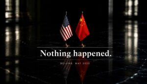 Minimalist editorial image featuring U.S. and Chinese desk flags on a glossy black surface beneath the phrase “Nothing happened.”