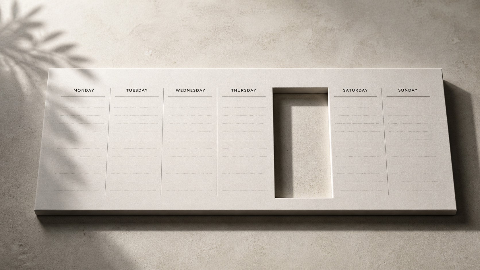 Minimalist weekly calendar on a neutral desk with one day precisely cut out, creating a clean rectangular void with soft shadow
