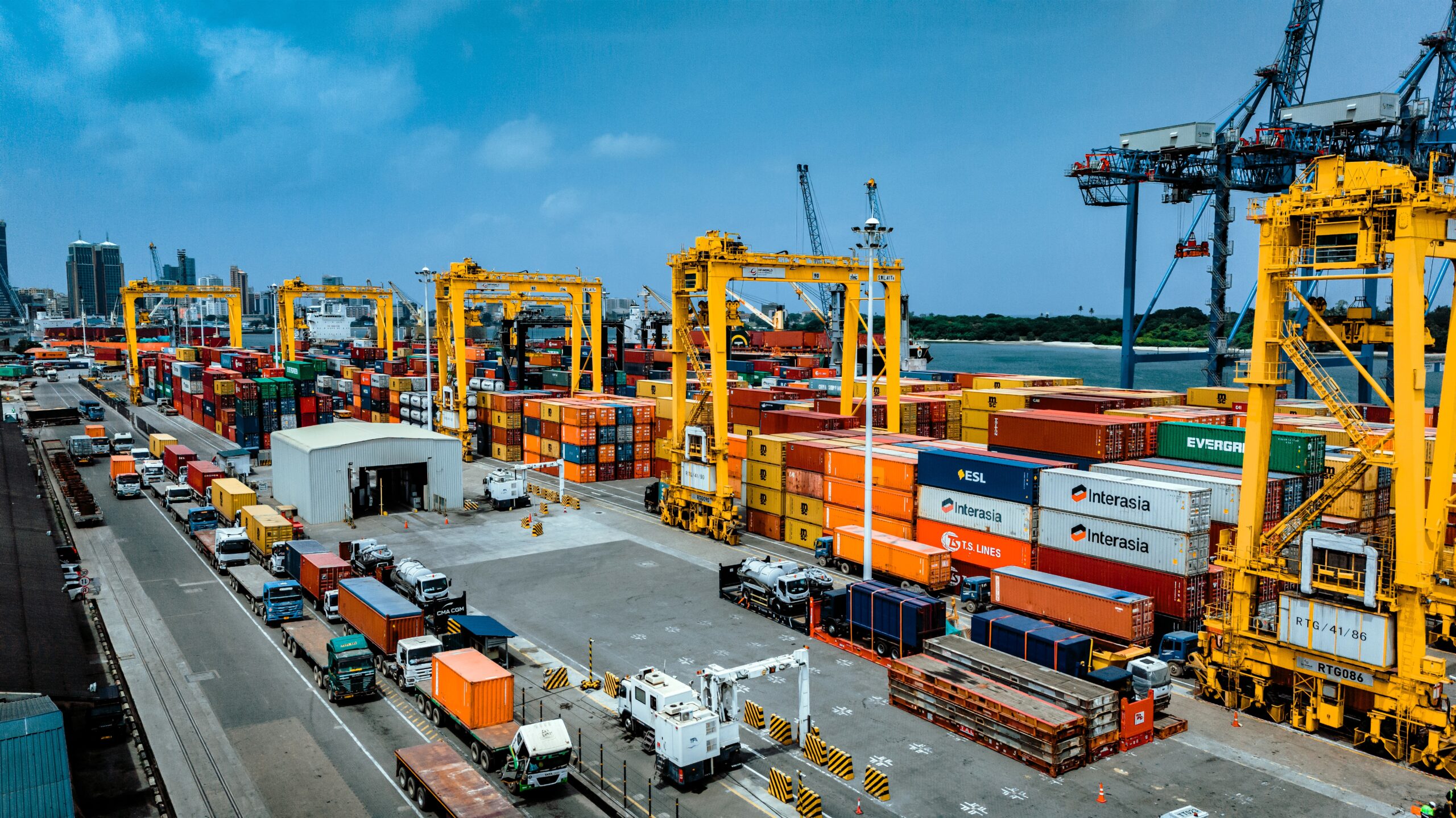 Aerial view of the Port of Dar es Salaam showing container terminals, gantry cranes, cargo vessels, trucks and stacked containers, highlighting Tanzania's expanding logistics infrastructure and its growing role in regional maritime trade