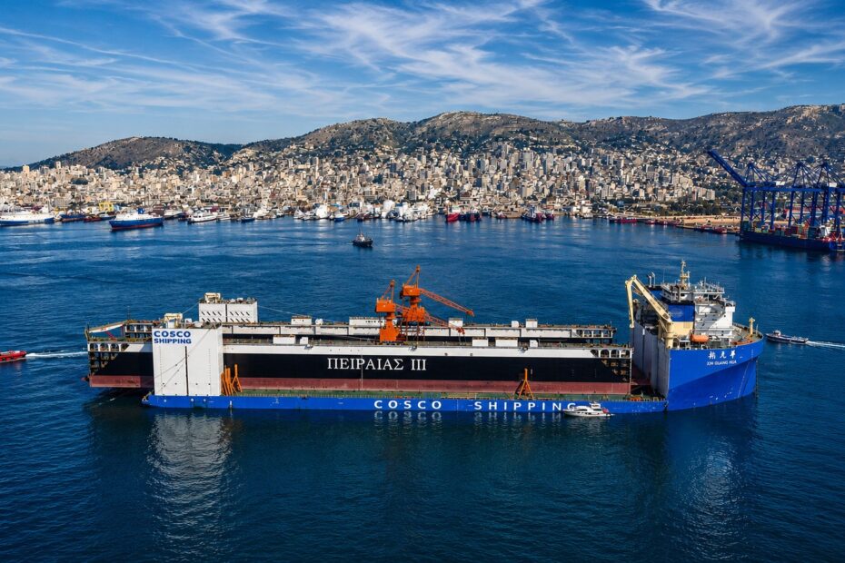 Panoramic view of Piraeus Port with a COSCO SHIPPING vessel in the foreground, container cranes, harbor infrastructure, and cityscape behind